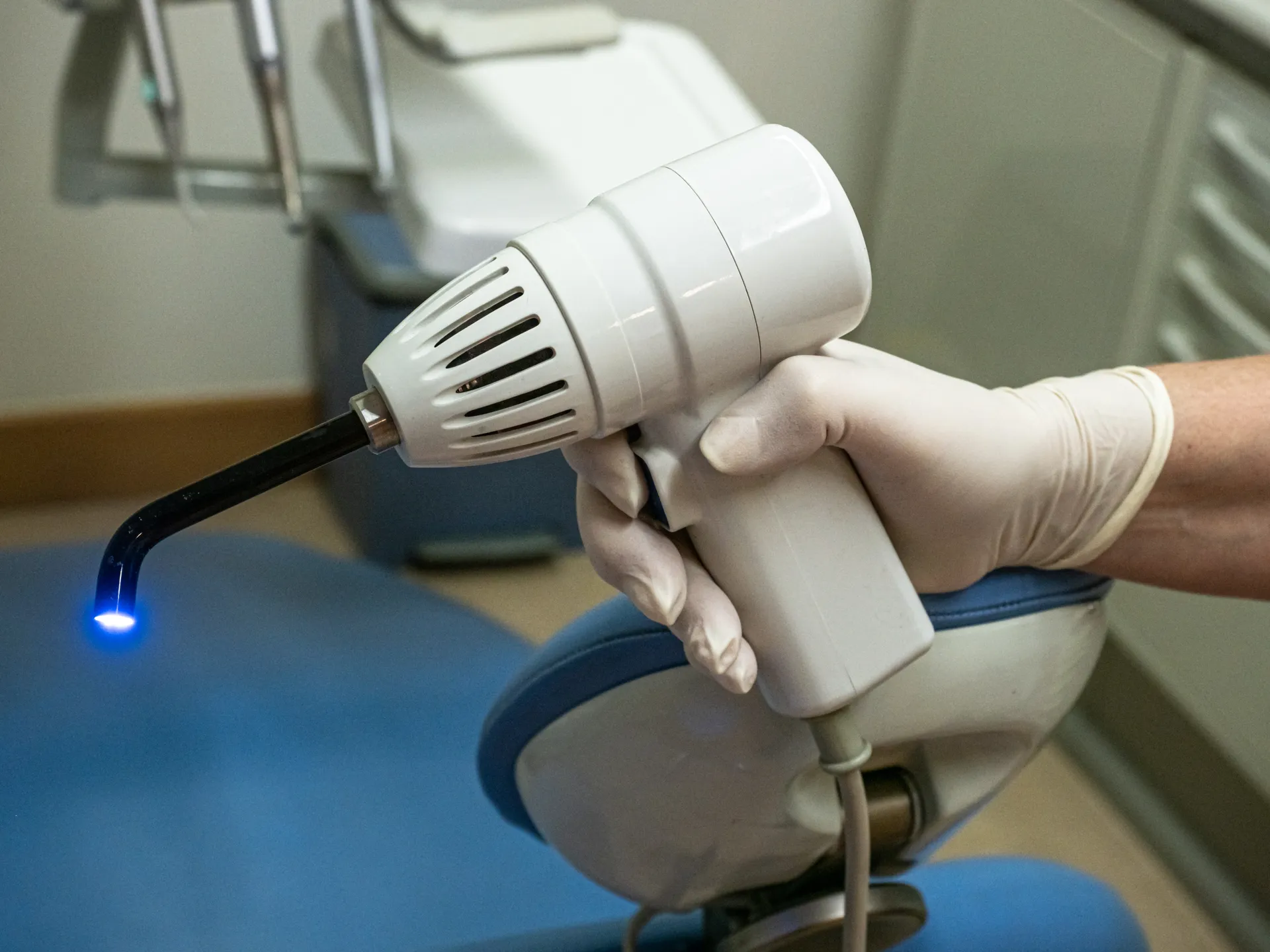 Dispositivo dental en mano de un dentista, utilizado para tratamientos de limpieza y cuidado bucal en un consultorio odontológico.
